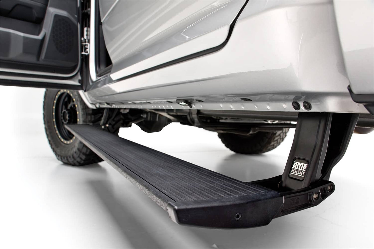 AMP Research Power Steps for 2022-2026 GM 1500 and 2023-2024 HD trucks, mounted on side of vehicle showing step mechanism