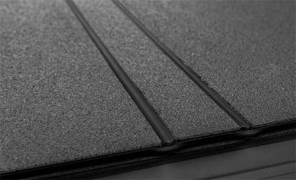Black ACI LOMAX hard folding tonneau cover on 2020-2026 Jeep Gladiator 5ft bed with Trail Rail system, low profile design.