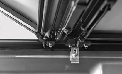 Black ACI LOMAX STANCE hard folding tonneau cover on a 2020-2026 Jeep Gladiator with Trail Rail system, showing its sleek design.