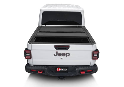 Matte aluminum BAKFlip MX4 hard folding tonneau cover on Jeep Gladiator 5ft bed, featuring tailgate lock system and 400lb capacity.