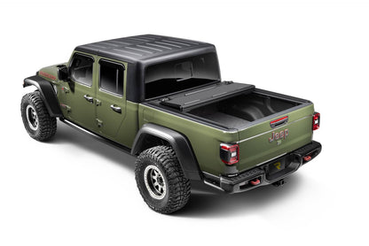 Open BAKFlip MX4 TS hard folding tonneau cover on Jeep Gladiator 5ft bed, showing full bed access with heavy-duty aluminum construction.