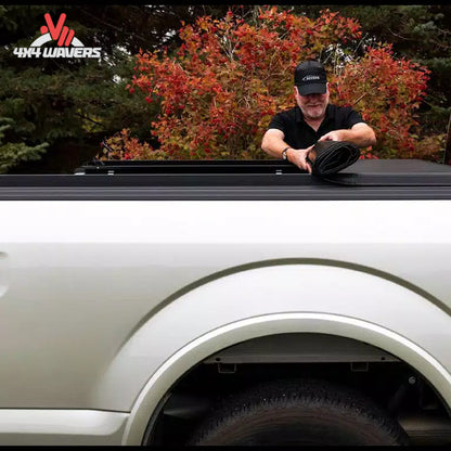 An 8 foot soft vinyl tonneau cover completely rolled up behind the truck cab showing open bed access SKU BGPC_11389.