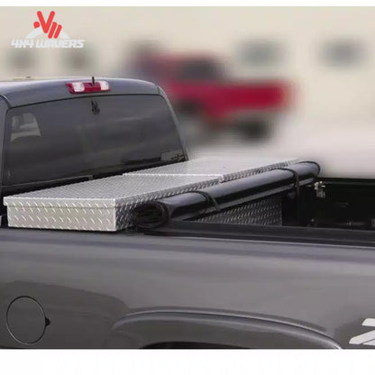 Close-up detail showing the aluminum header bar and foam gasket sealing the tonneau cover against the back of a metal crossover toolbox SKU BGPC_61379.
