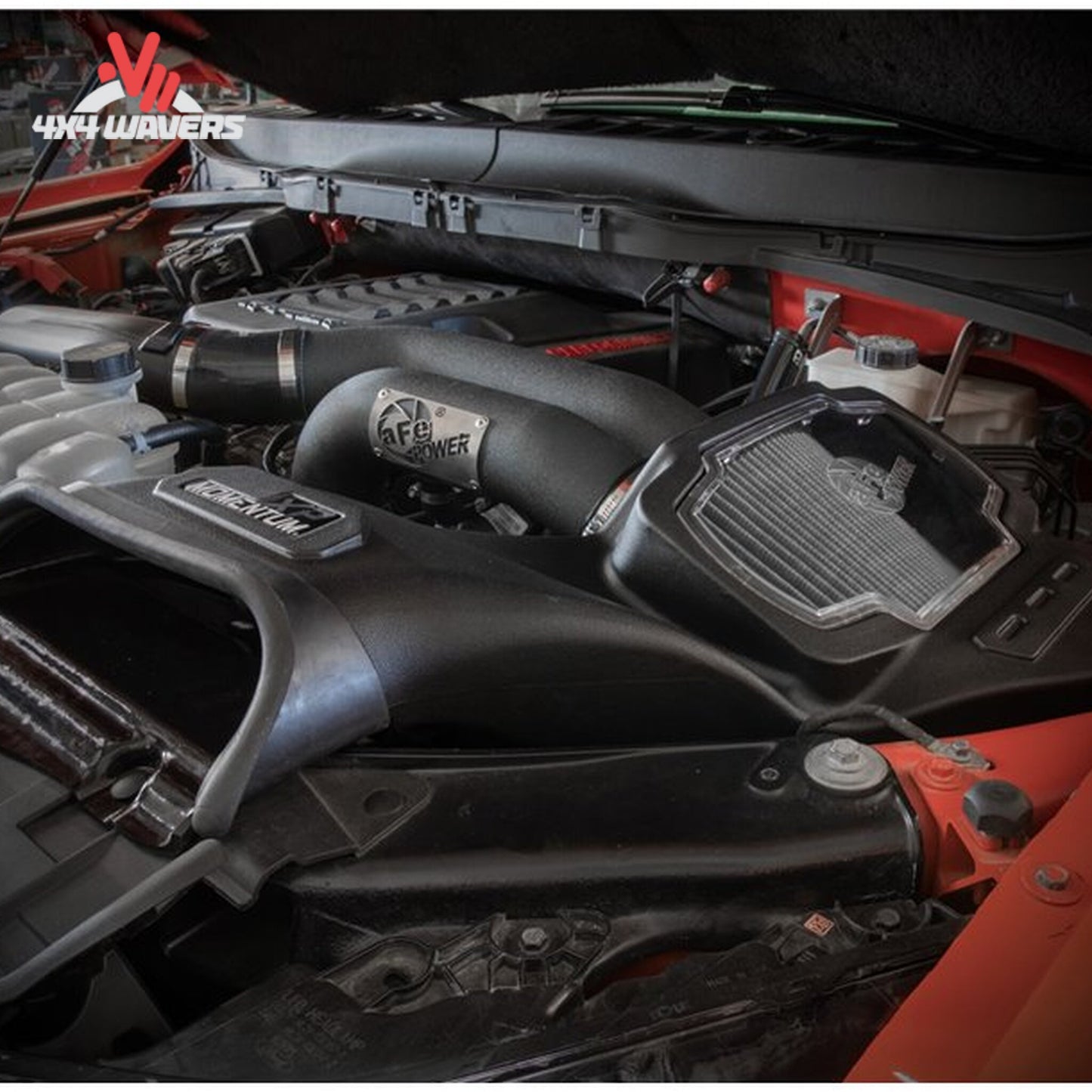 An installed aFe cold air intake with dual black aluminum tubes connected to turbos inside a Ford F-150 engine compartment SKU BKJC_50-30072D.