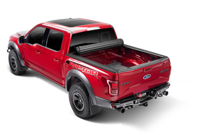 Open BAK Revolver X4s hard roll-up tonneau cover in matte black on Jeep Gladiator 5ft bed, showing aluminum slats and roll-up mechanism.