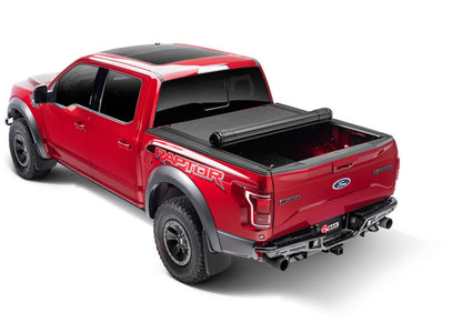BAK Revolver X4s roll-up tonneau cover open on a Jeep Gladiator 5ft bed, matte black aluminum slats, rugged truck bed cover
