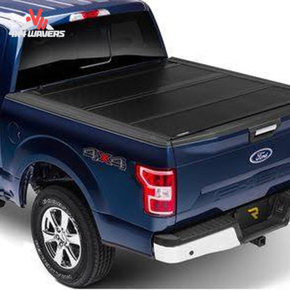 A black tonneau cover installed on the bed of a blue Ford pickup truck, shown from a rear three-quarter angle against a white background.