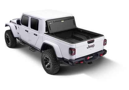 BAKFlip MX4 hard folding tonneau cover on Jeep Gladiator 5ft bed, matte aluminum finish, folded open showing tailgate lock system