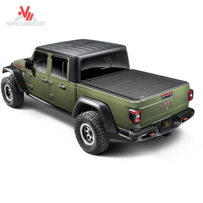 Cubierta tonneau rígida plegable BAKFlip MX4 TS instalada en una Jeep Gladiator JT 2020-2026, mostrando su diseño negro duradero y su seguro mecanismo de cierre.