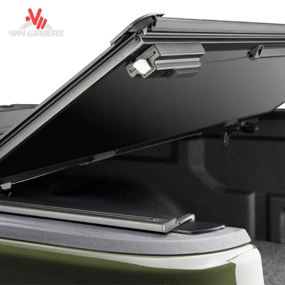 Matte negro BAKFlip MX4 TS cubierta rígida plegable tipo tonneau en un Jeep Gladiator JT 2020-2026, mostrando paneles plegados y diseño elegante.