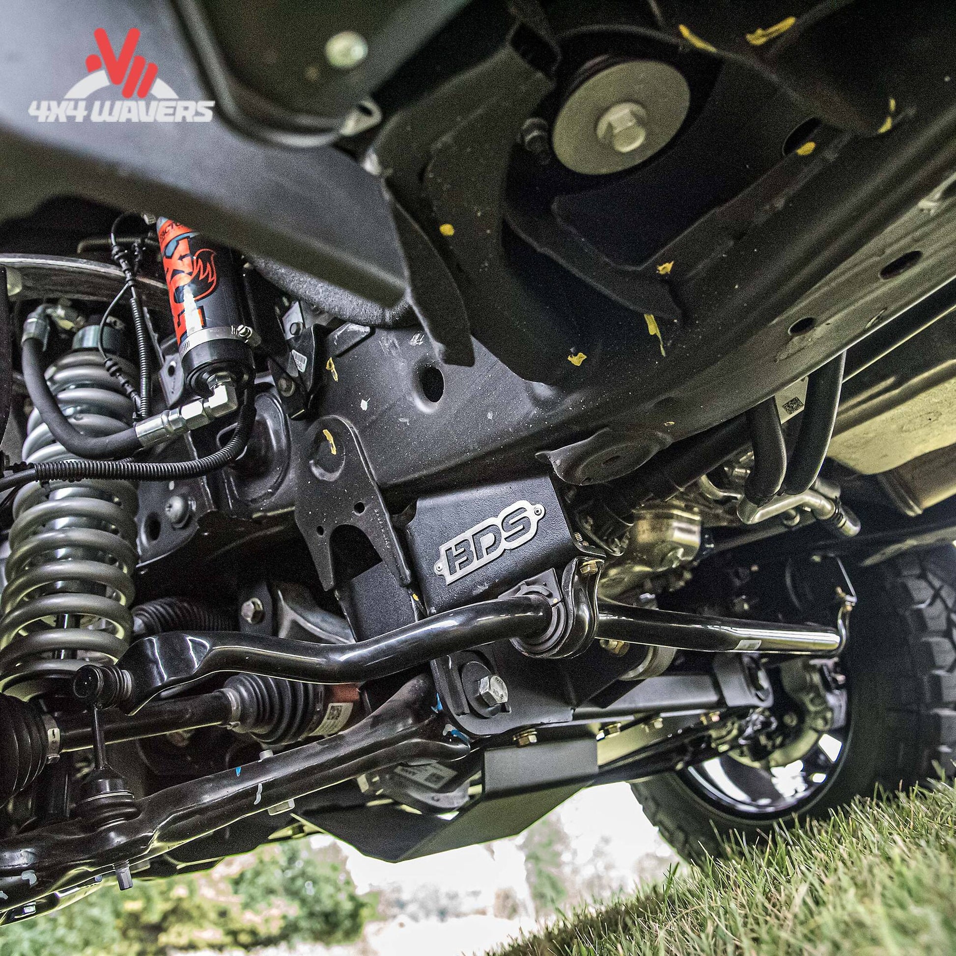 Close-up undercarriage of a vehicle showing a black metal frame and suspension components.