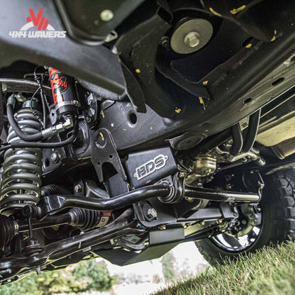 Close-up undercarriage of a vehicle showing a black metal frame and suspension components.