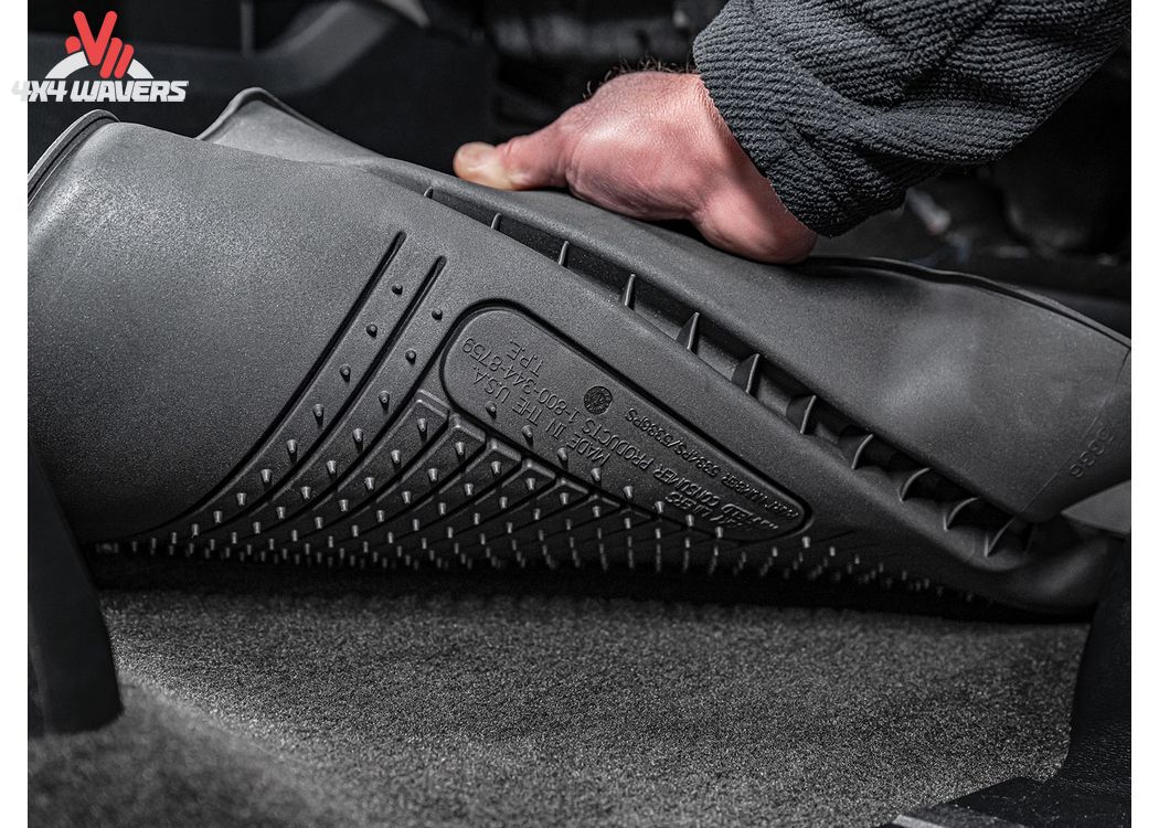 Close-up of black Husky WeatherBeater TPO floor liners for 2018-2025 Jeep Wrangler JL 4-door, showing textured surface and fit.