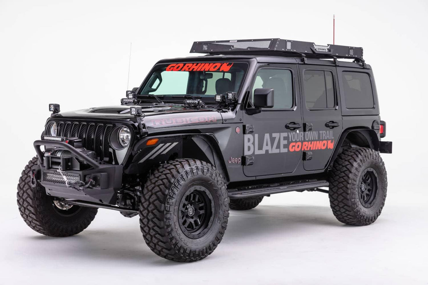 Go Rhino Rockline Stubby front winch bumper with overrider bar on a Jeep JL or Gladiator JT, showing the angled view of the bumper.