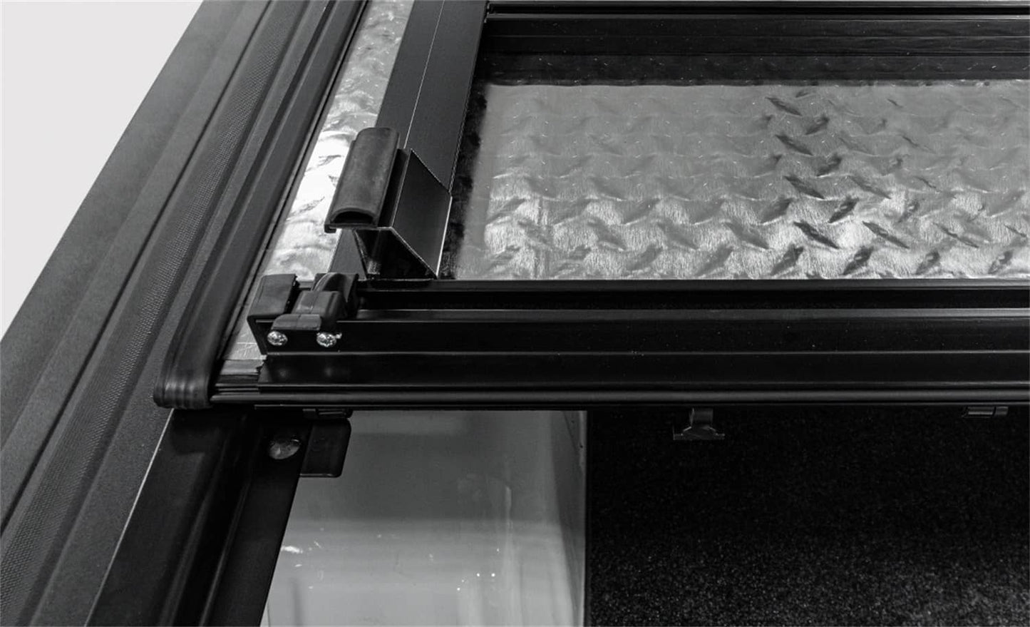 Open LOMAX hard folding tonneau cover on a 2020-2026 Jeep Gladiator with black finish and trail rail system, showing its low profile design.