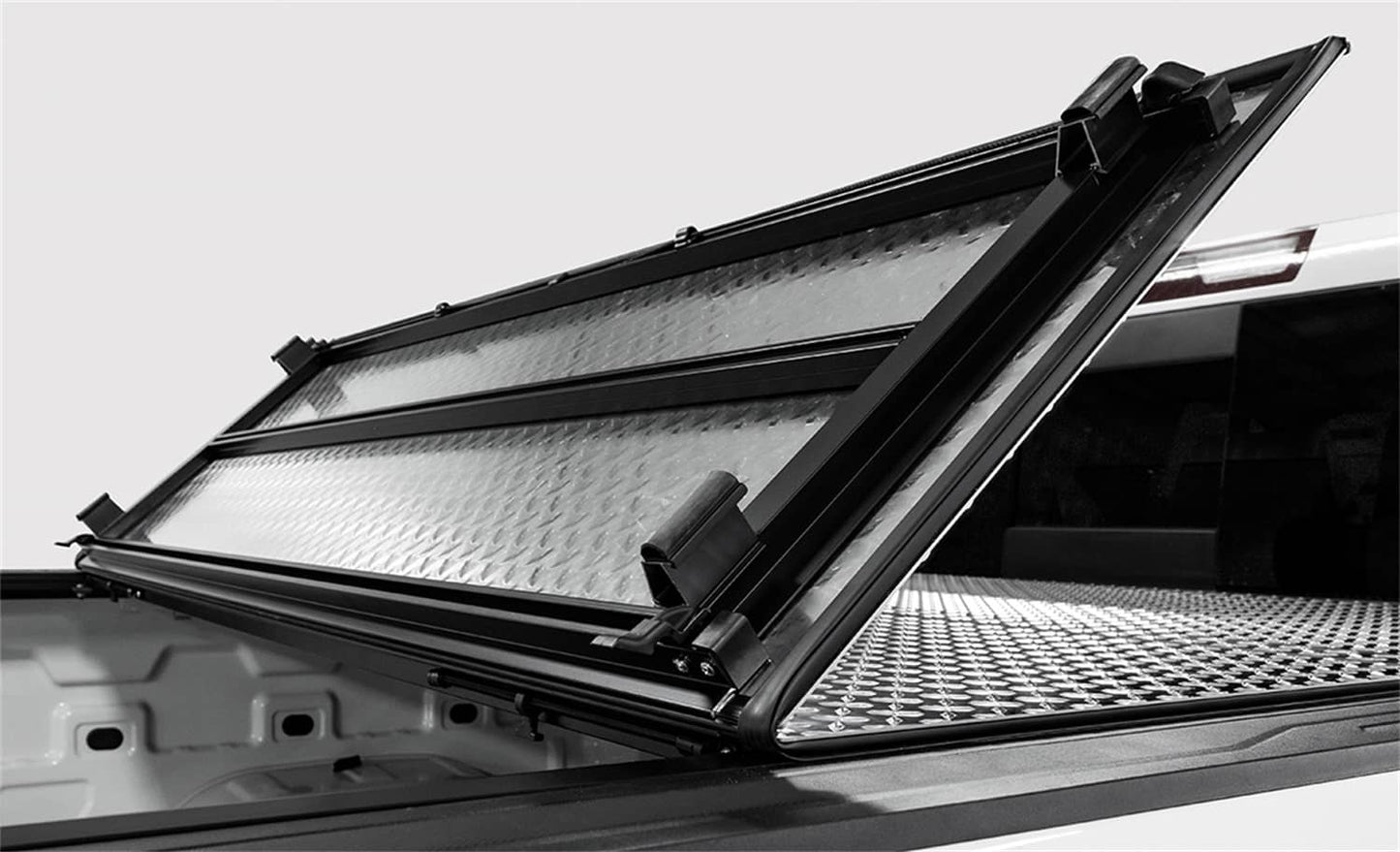 Open view of ACI LOMAX hard folding tonneau cover on 2020-2026 Jeep Gladiator 5ft bed with Trail Rail system, black low profile finish.