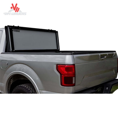 A black LOMAX Stance hard tonneau cover installed on a 2004-2026 Ford F-150 with a 5.5ft bed, shown on a pickup truck.
