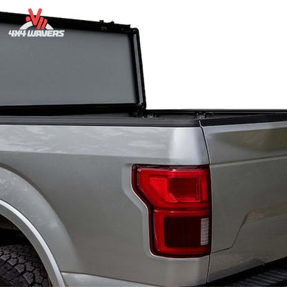 A black Lomax Stance Tonneau Cover by ACI on a 2004-2026 Ford F-150 with a 5.5ft truck bed, installed on the truck bed.