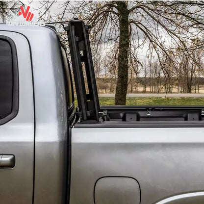 The hard folding tonneau cover locked securely in an upright vertical position away from the rear window glass.