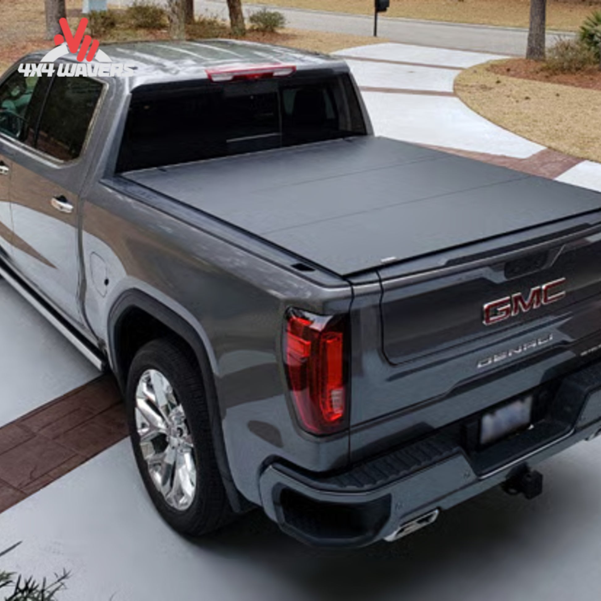 Cubierta rígida plegable tonneau ACI LOMAX Stance en una Jeep Gladiator JT 2020-2026 con sistema Trail Rail, mostrada sobre la caja de una camioneta.