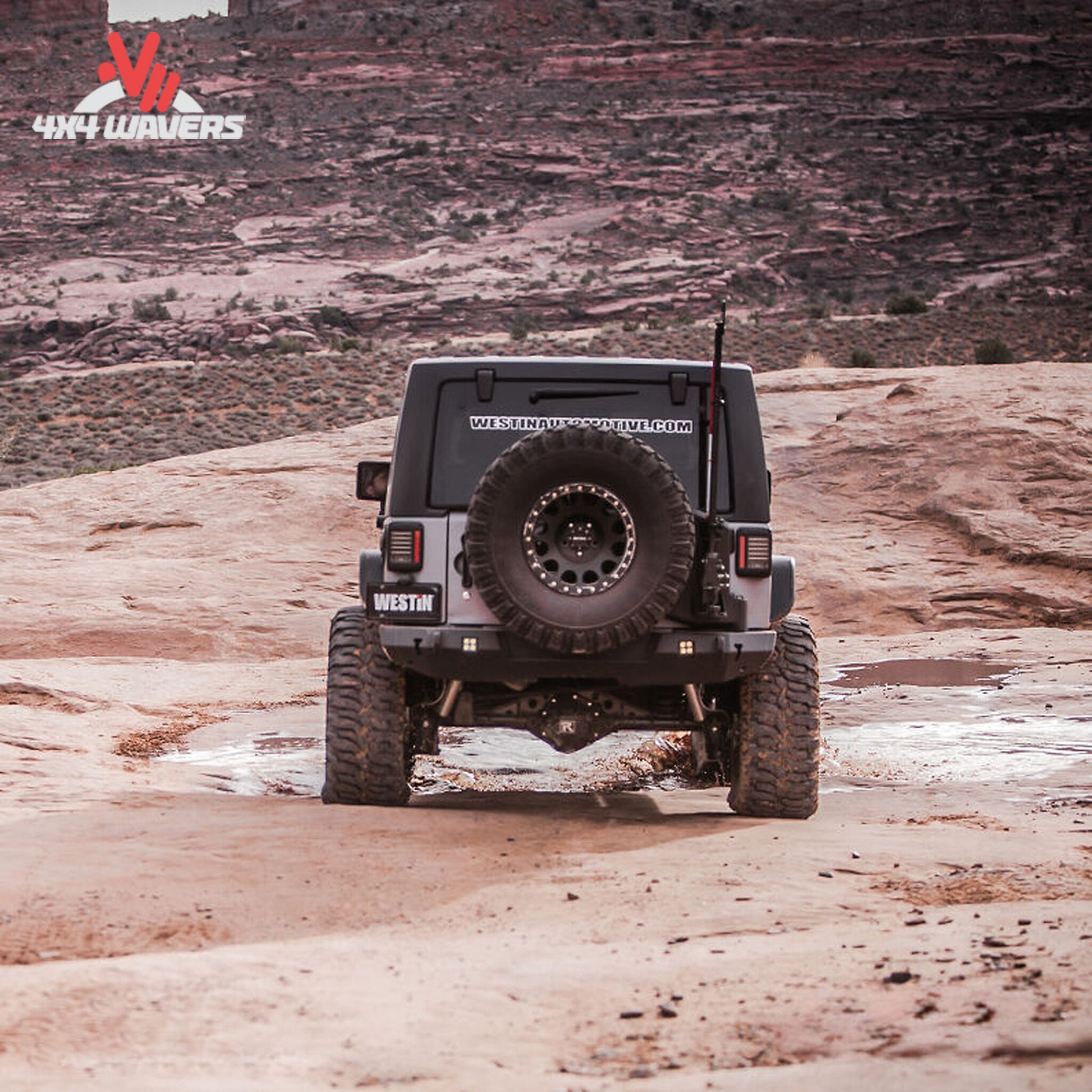 Rear view showing Westin WJ2 bumper, spare tire carrier, recovery points, and off-road protection features
