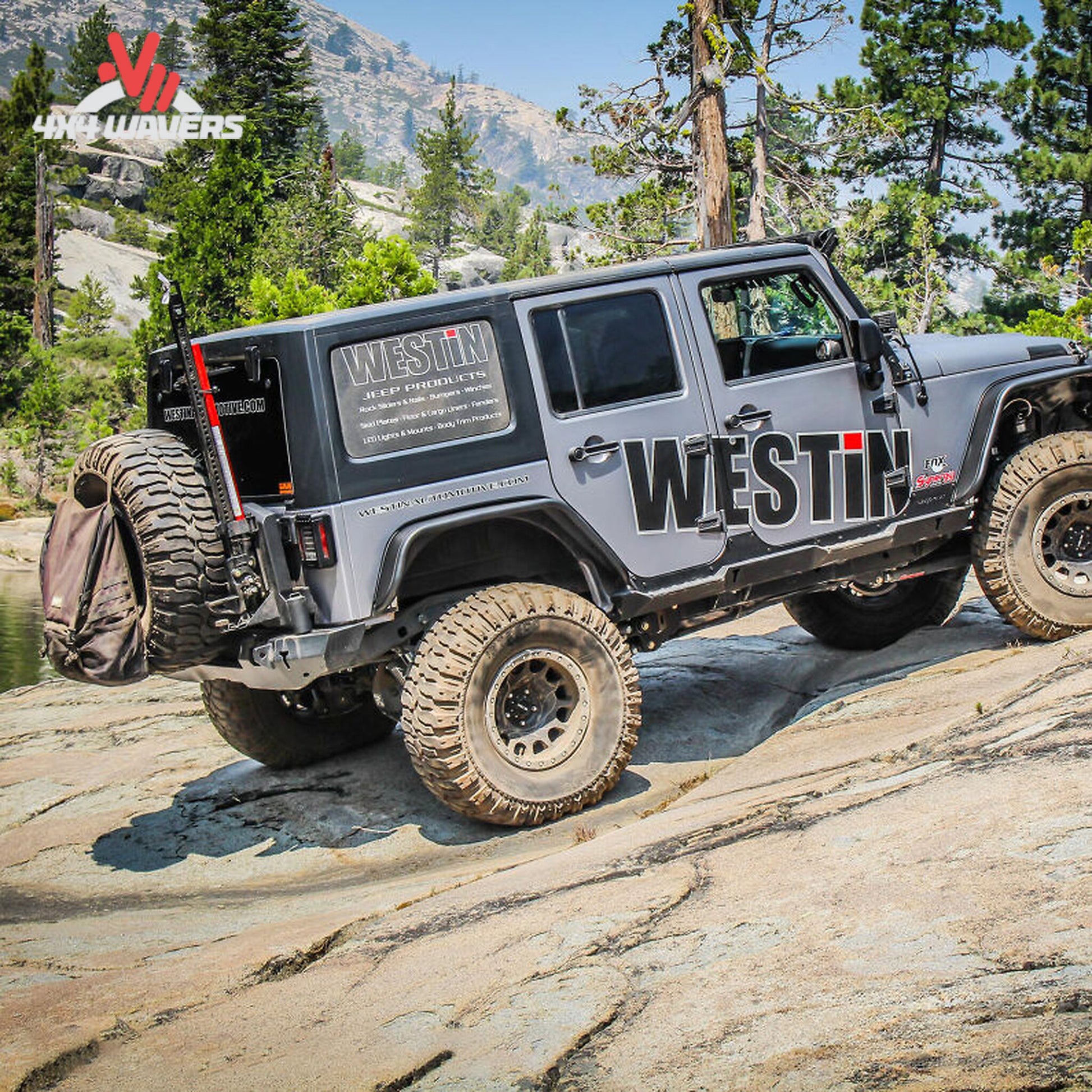 Rear view showing Westin WJ2 bumper, spare tire carrier, recovery points, and off-road protection features